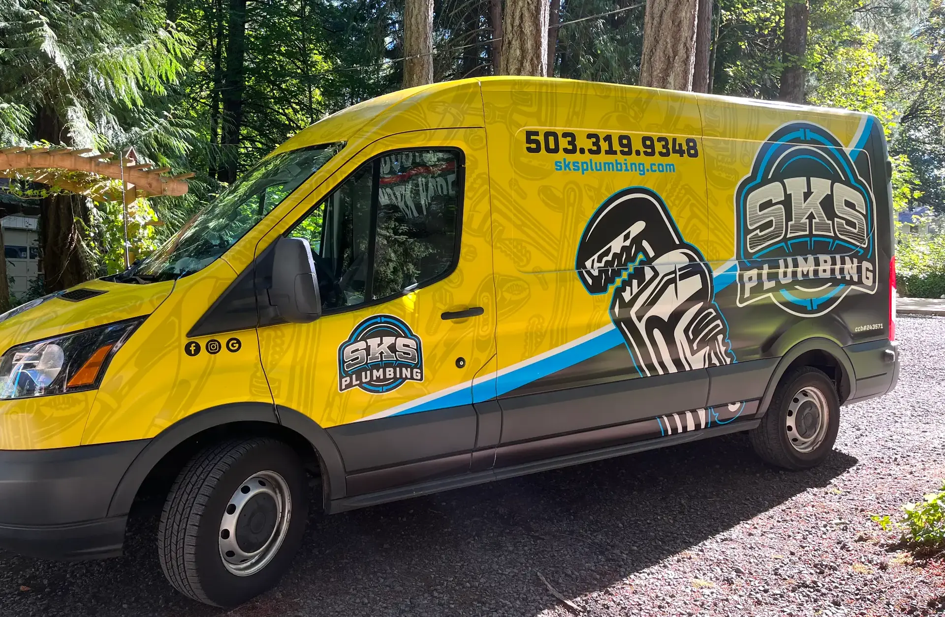 Side view of the SKS Plumbing service van showing the company logo and licence number